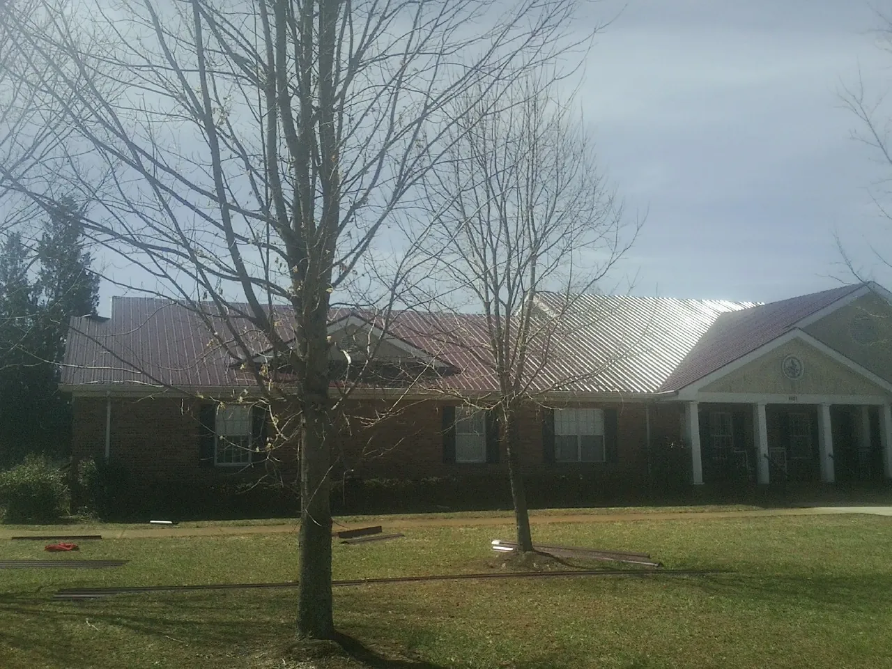 Red metal roof on a brick building seen from the front lawn in Slippery Rock