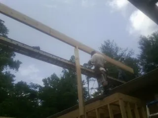 Carpenter setting a ridge beam over a new addition frame — Ice Dam Removal by Roofing Brothers in Slippery Rock