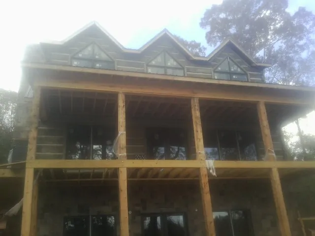 Dormers and porch framing on a large log home under construction — Roof Coating work by our crew in Slippery Rock