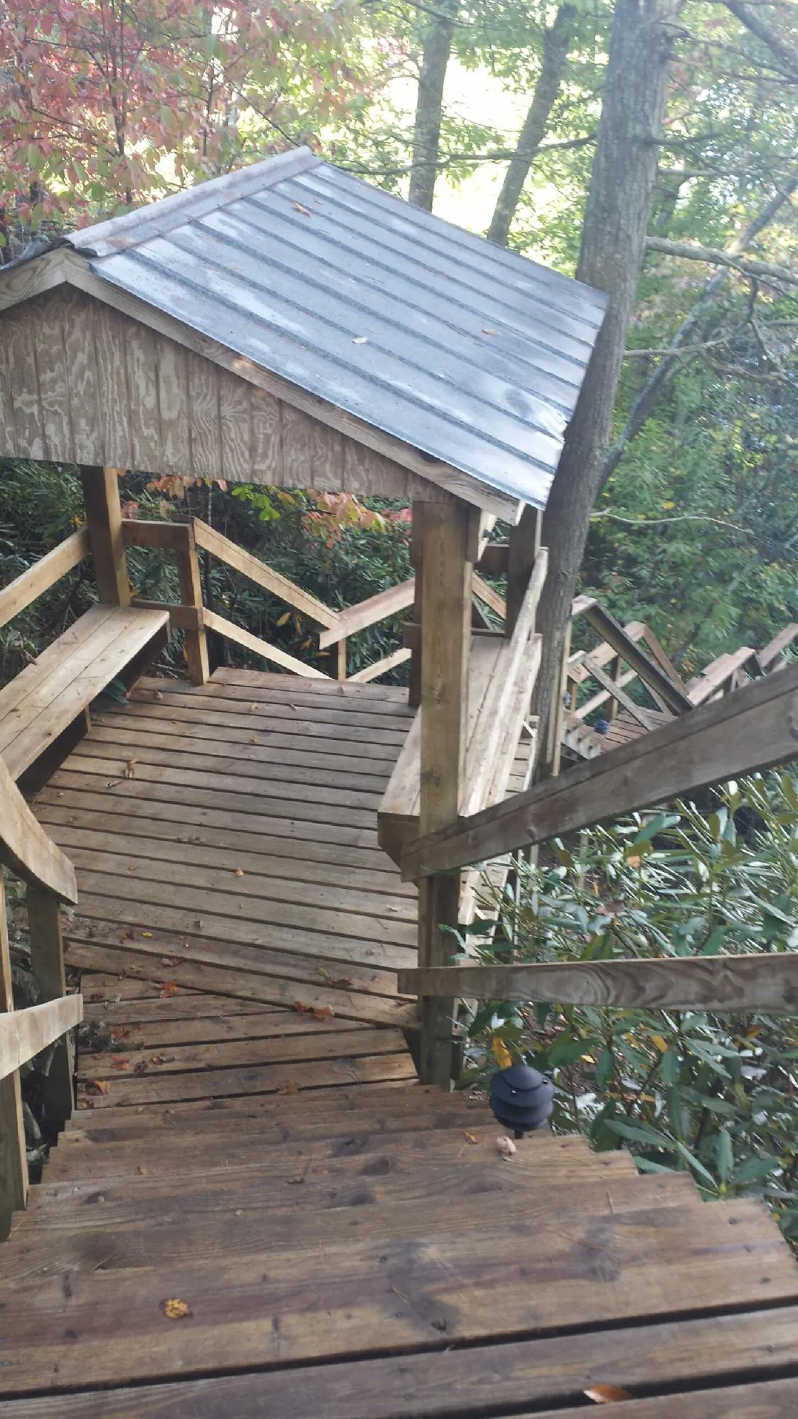 Metal roofed shelter over wooden steps on a wooded walkway — Skylight Repair & Installation work by our crew in Slippery Rock