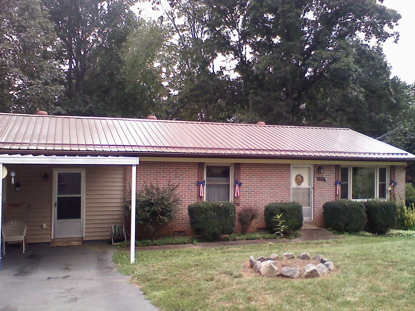 Bronze metal roof and carport on a brick ranch home — Roof Repair work by our crew in Slippery Rock